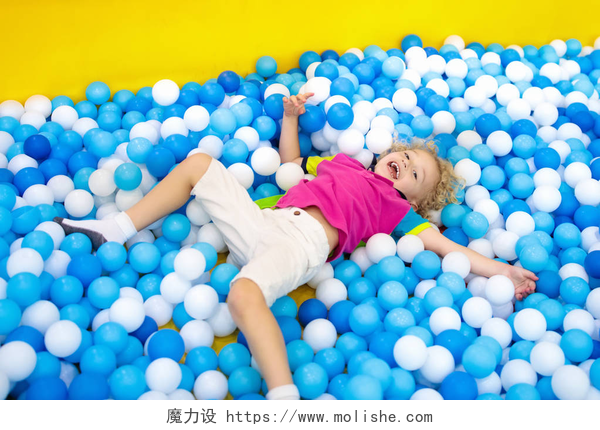 孩子开心的躺在彩色球体上孩子们在球坑里玩耍。玩球池的孩子
